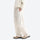Water-repellent nylon hiking pants with relaxed fit - cream white wide-leg hiking pants with cream top, side walking view