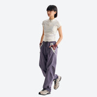 
                  
                    Breathable relaxed trail pants with drawcord waist - mauve purple quick-dry hiking pants with white tee, side walking view
                  
                