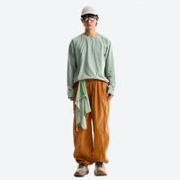 
                  
                    Breathable loose-fit trail pants with mesh lining - orange hiking pants with sage top, for warm-weather adventures
                  
                