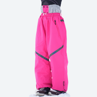 
                  
                    Breathable ski jacket and snow pants combo - red, on-model front holding snowboard horizontal, for skiing and snowboarding
                  
                