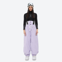 
                  
                    Women's 2-layer snowboard jacket and bibs - lavender bib pants with black top, for powder days and winter commute
                  
                